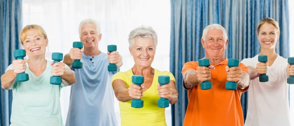 groupe de personnes seniors qui réalisent des exercices de gym douce avec un coach