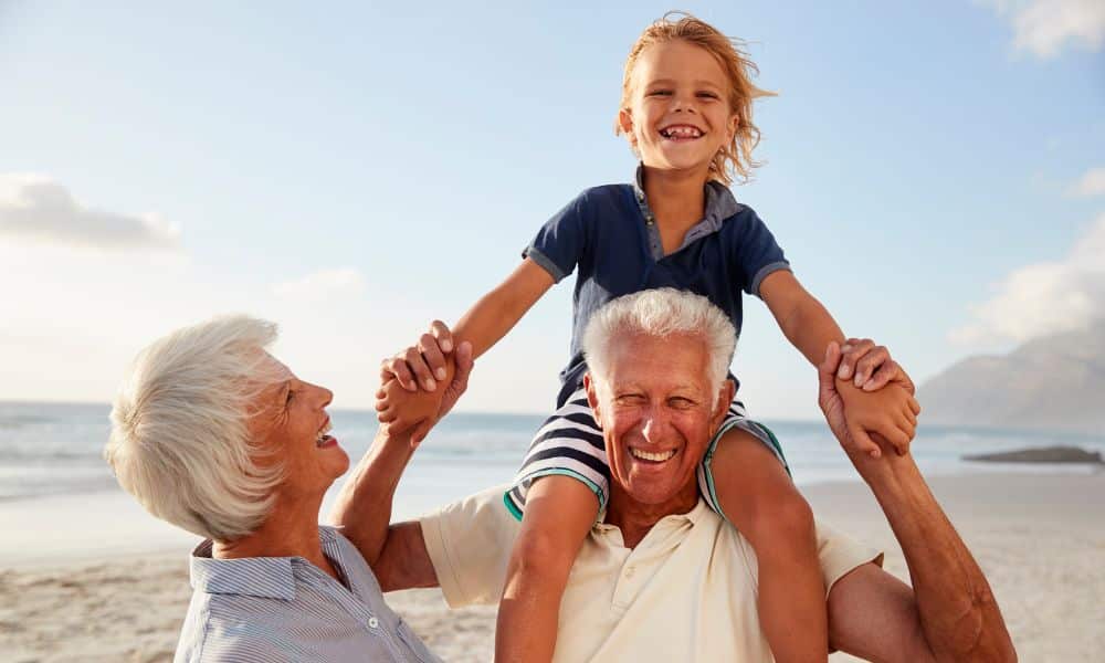 petit fils sur les épaules de son grand pere plage
